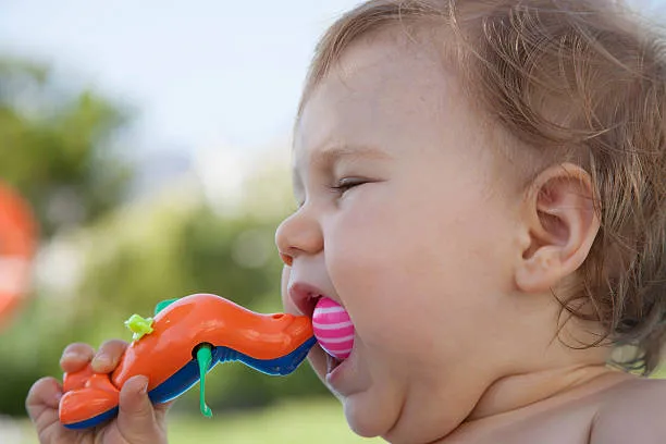 baby eating plastic toy
