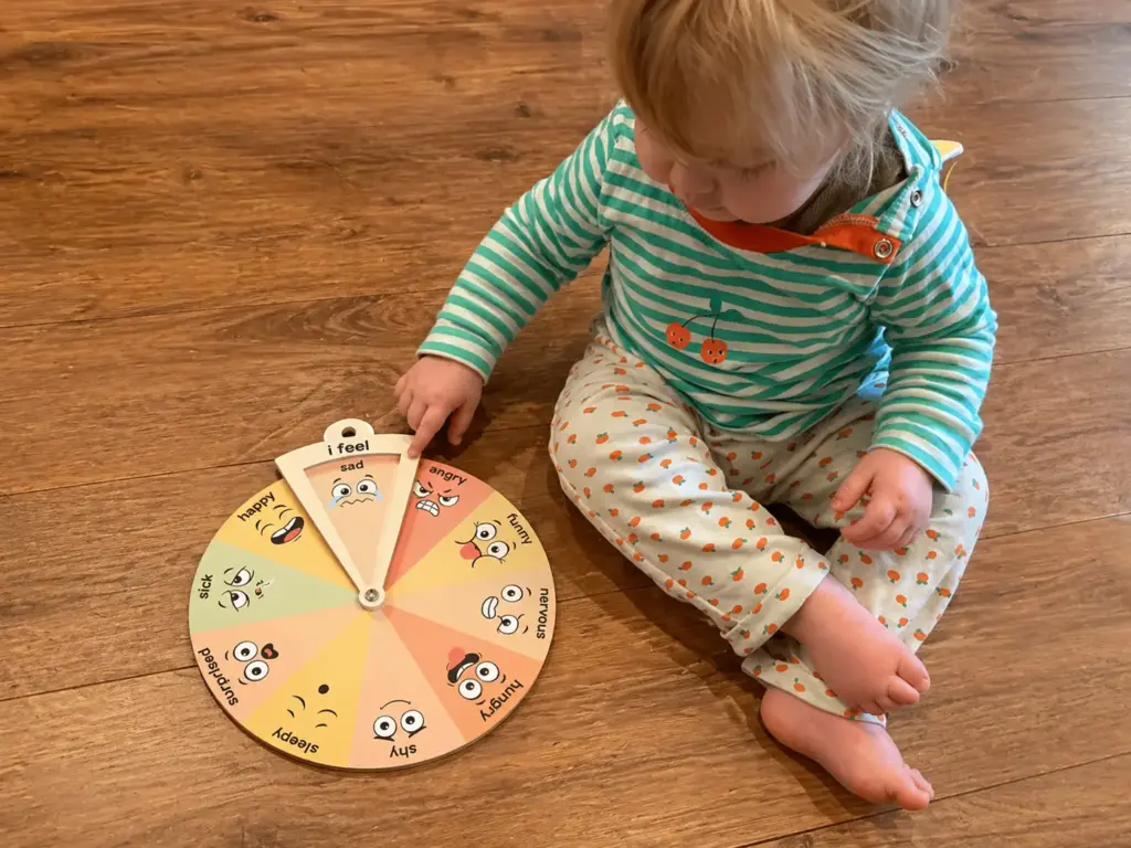toddler playing with emotion wheel
