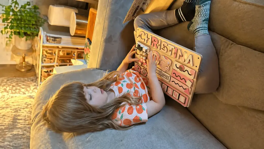 toodler is playing with busy board