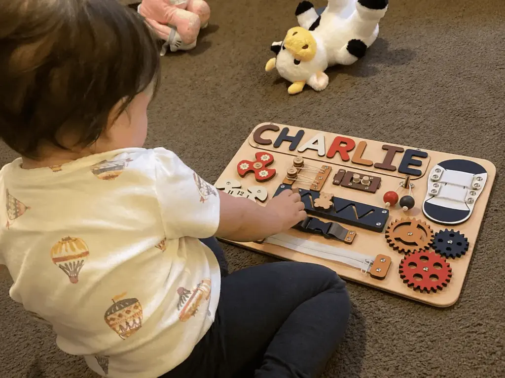 baby exploring busy board