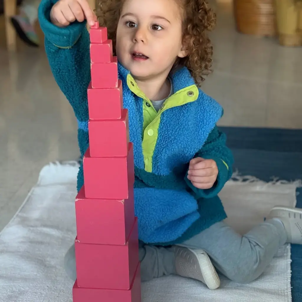 children builds pink tower