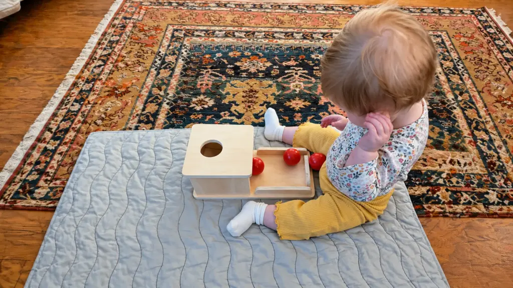 toddler playing with object permanence box